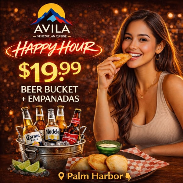 A woman smiles while eating an empanada, next to a beer bucket and empanadas with dip.